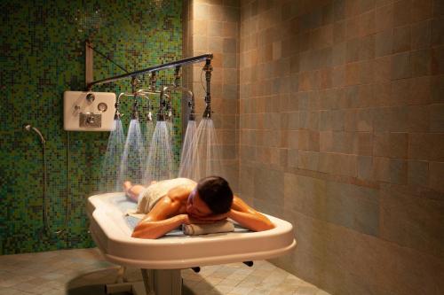 a man laying in a sink in a bathroom at Hilton Beachfront Resort & Spa Hilton Head Island in Hilton Head Island