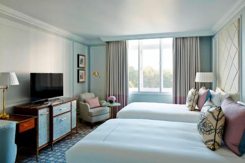 ロンドンにあるロンドン マリオット ホテル パーク レーンのベッド2台とテレビが備わるホテルルームです。