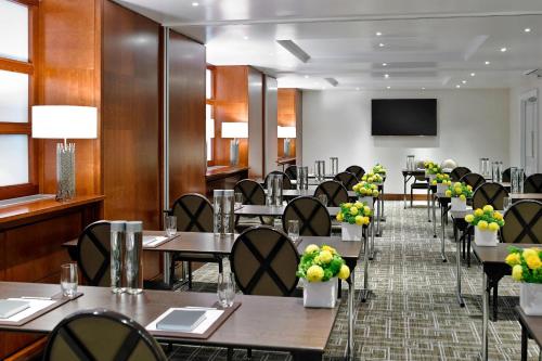 a restaurant with tables and chairs and a flat screen tv at London Marriott Hotel Park Lane in London