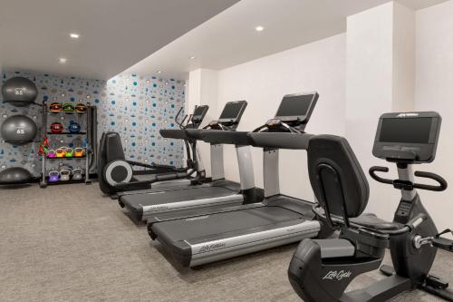 a gym with several tread machines and a tv at Le Meridien New York, Fifth Avenue in New York