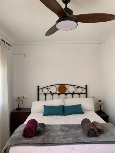 a bedroom with a bed with a ceiling fan at Adosado tranquilo con piscina y vistas al mar in Puerto Marino