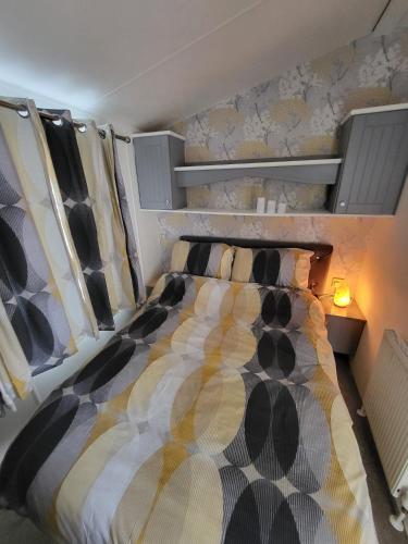 a bedroom with a large bed with a wall at Haven Dreams Caravan in Hastings