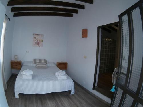 1 dormitorio con 1 cama con toallas en CAN JAUME D’EN PEP MIQUEL, en Sant Francesc Xavier
