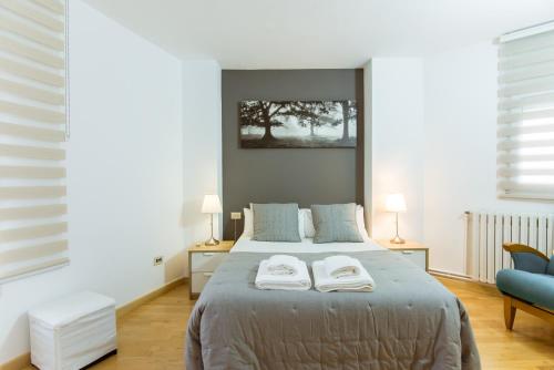 1 dormitorio con 1 cama con 2 toallas en Two bedroom TownHouse within 10min walk from Beach, en Barcelona