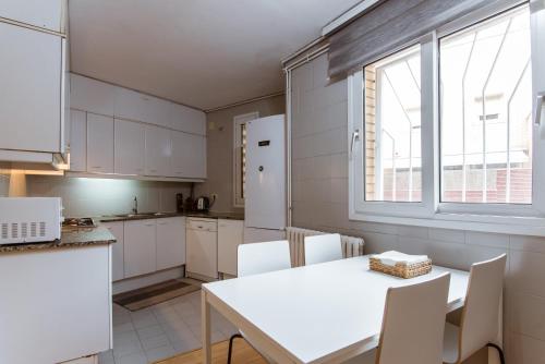 une cuisine avec une table blanche et des armoires blanches dans l'établissement Two bedroom TownHouse within 10min walk from Beach, à Barcelone