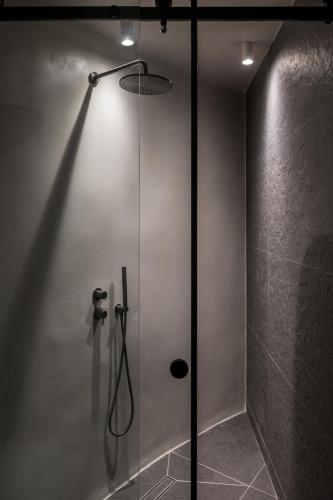 a shower with a glass door in a bathroom at Honeymoon Petra Villas in Imerovigli