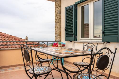 uma mesa e cadeiras numa varanda com uma janela em Villa Emma em Castellabate