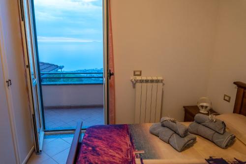 um quarto com uma cama e uma grande janela em Villa Emma em Castellabate