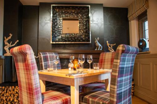 a dining room with a table and two chairs with wine glasses at Hopping Hare in Northampton