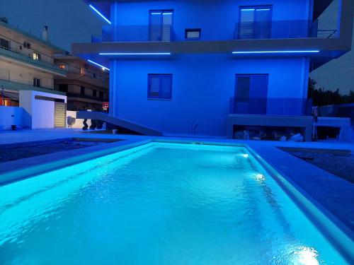 a swimming pool in front of a house at night at Luana Monte Apartments in Amoudara Herakliou