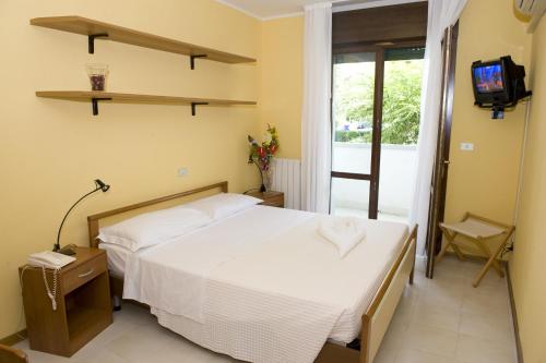 ein Schlafzimmer mit einem Bett und einem TV an der Wand in der Unterkunft Hotel Rosa Dei Venti in Lignano Sabbiadoro