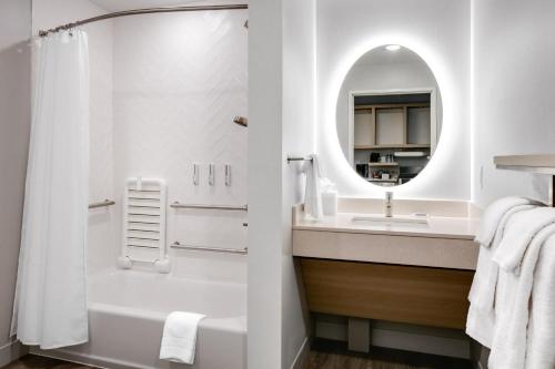 a bathroom with a shower and a sink and a mirror at TownePlace Suites by Marriott Madison West, Middleton in Madison