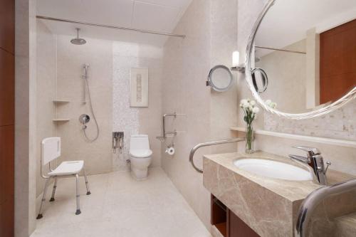 a bathroom with a sink and a toilet and a mirror at Shanghai Marriott Marquis City Centre in Shanghai