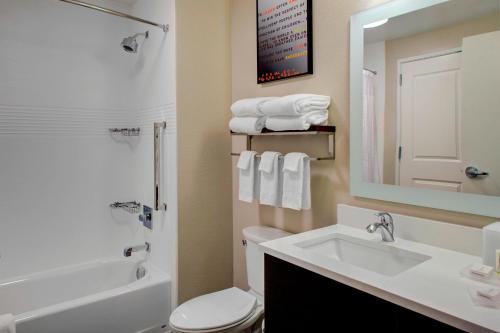 een badkamer met een wastafel, een toilet en een spiegel bij TownePlace Suites by Marriott Phoenix Chandler/Fashion Center in Chandler