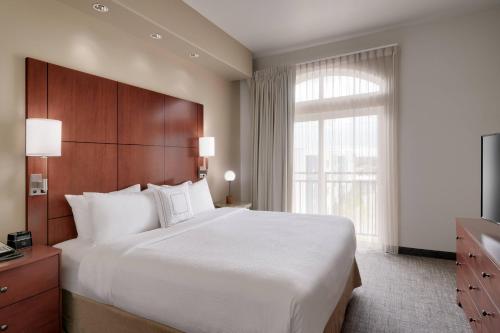 Un dormitorio con una gran cama blanca y una ventana en Residence Inn by Marriott Idaho Falls, en Idaho Falls