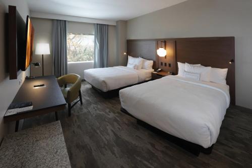 a hotel room with two beds and a desk at Fairfield Inn & Suites by Marriott Mexicali in Mexicali