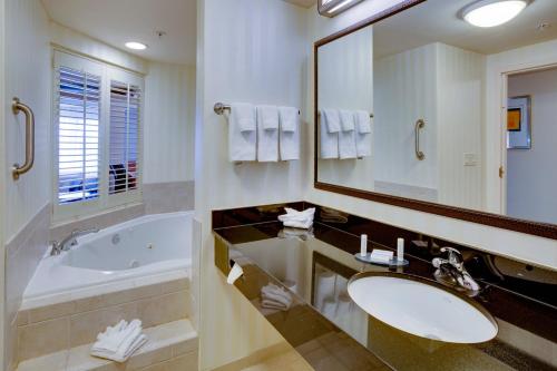 bagno con vasca, lavandino e specchio di Fairfield by Marriott Inn & Suites Melbourne West/Palm Bay a Melbourne
