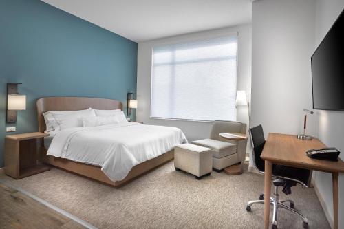 a bedroom with a bed and a desk and a television at Element Edmonton West in Edmonton