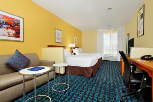 Habitación de hotel con cama, sofá y escritorio en Fairfield Inn & Suites by Marriott Fairfield Napa Valley Area, en Fairfield
