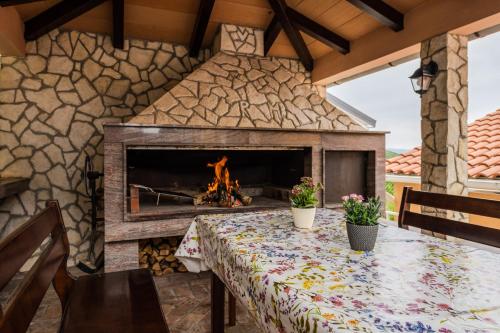a stone fireplace in a patio with a table and a fire place at Panoramare Komplex Vesna in Zagorje