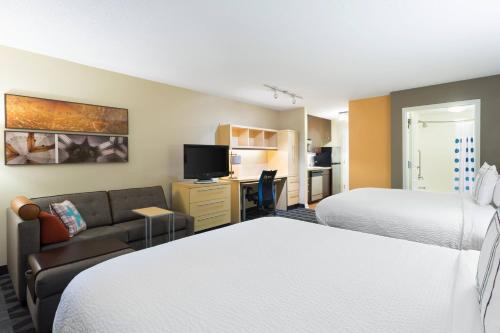 ボージャーシティにあるTownePlace Suites by Marriott Bossier Cityのベッド2台とソファが備わるホテルルームです。