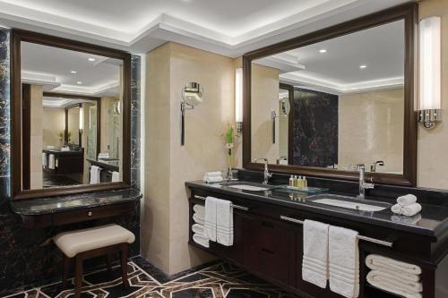 فندق ماريوت الرياض في الرياض: حمام مع حوض ومرآة كبيرة