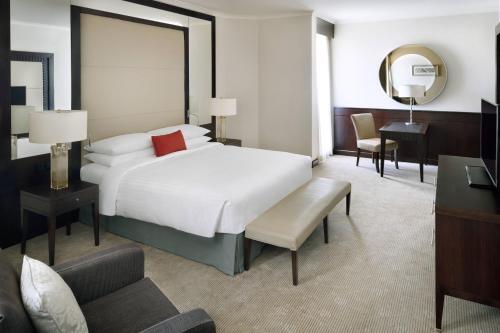 فندق ماريوت الرياض في الرياض: غرفة نوم مع سرير أبيض كبير ومكتب