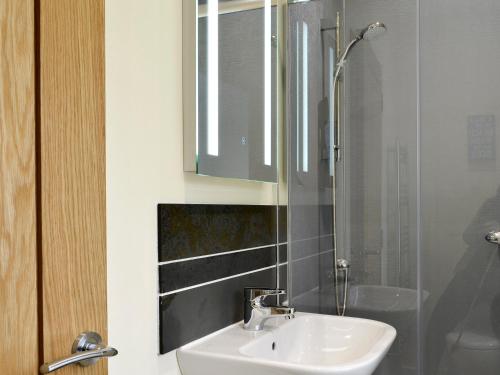 y baño con lavabo y ducha. en Hameish Holiday Cottage, en Kirkcudbright