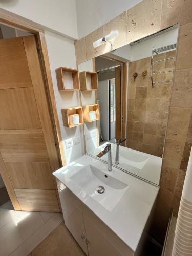 une salle de bain avec un lavabo, un miroir et une douche dans l'établissement Duplex T3 Boulouris Pieds dans l eau, à Saint-Raphaël