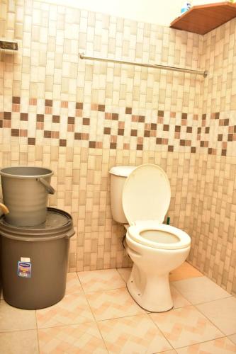 - une salle de bains avec toilettes et deux poubelles dans l'établissement Warm & Spacious 1br in Lower Kabete near KSG, à Nairobi