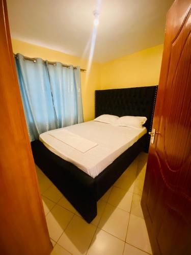 Cette petite chambre comprend un lit avec des draps blancs. dans l'établissement Warm & Spacious 1br in Lower Kabete near KSG, à Nairobi