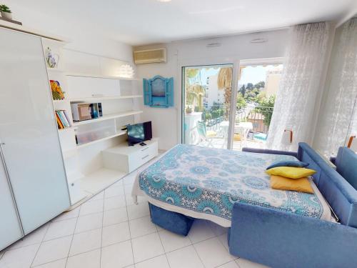 une chambre avec un lit et un canapé bleu dans l'établissement Studio climatisé avec terrasse ensoleillée, proche plages et centre, Menton - FR-1-196-314, à Menton