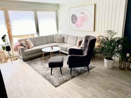 een woonkamer met een bank en een tafel bij Moderne og sentral leilighet med koselig og privat uteplass! in Hornnes