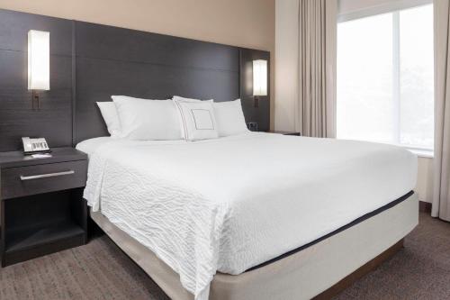 a large white bed in a hotel room at Residence Inn by Marriott St. Louis West County in Saint Louis