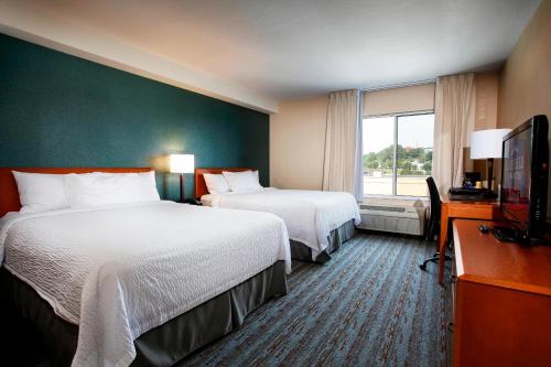 a hotel room with two beds and a flat screen tv at Marriott Fairfield Sudbury in Sudbury