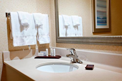 a bathroom with a sink and a mirror and towels at Marriott Fairfield Sudbury in Sudbury