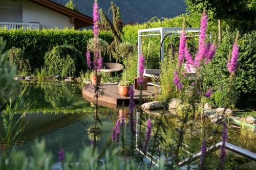 un jardín con un muelle de madera en el agua en Hotel Rössl en Rablà