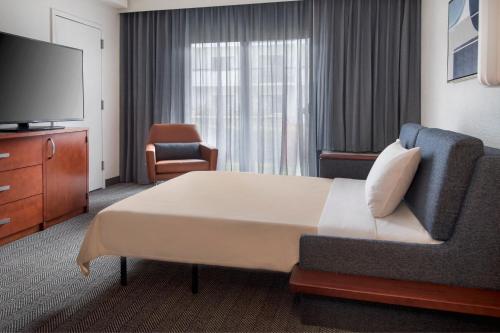 銀泉的住宿－銀泉北/白橡木萬怡酒店，酒店客房设有一张大床和一台电视。