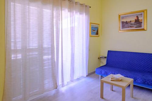 a living room with a blue couch and a window at Casa del sol 2 bedrooms in Morro del Jable