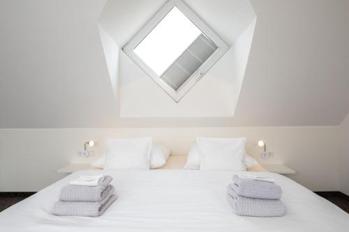 a bedroom with a white bed with a skylight at Wohnung Bontje in Juist