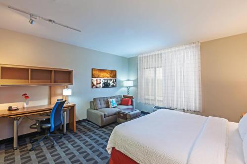 a hotel room with a bed and a desk at TownePlace Suites by Marriott Tulsa North/Owasso in Owasso