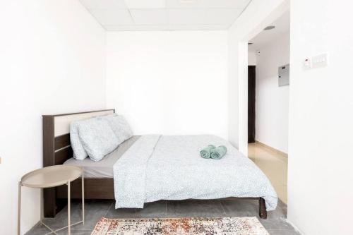 a white bedroom with a bed and a stool at Window for Dubai in Dubai