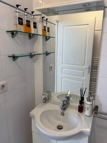 une salle de bain blanche avec un lavabo et un miroir dans l'établissement charmant studio à Menton, à Menton