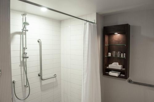 a bathroom with a shower with a shower curtain at Delta Hotels by Marriott Saguenay Conference Centre in Saguenay