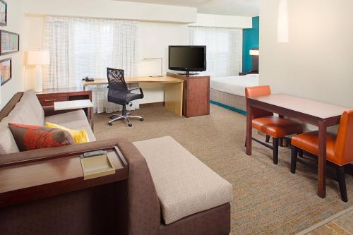 a hotel room with a couch and a desk at Residence Inn Richmond Northwest in Broad Meadows