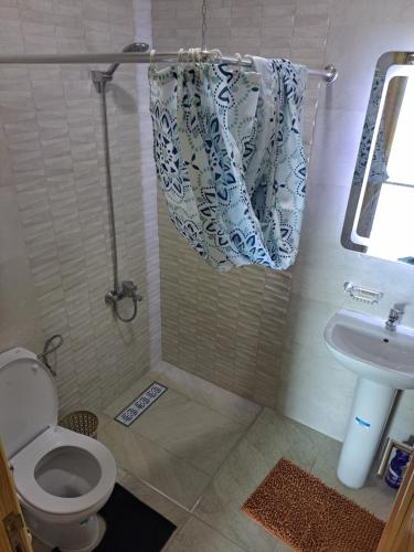 a bathroom with a toilet and a sink at Ghougine Serenity Residence in Tangier