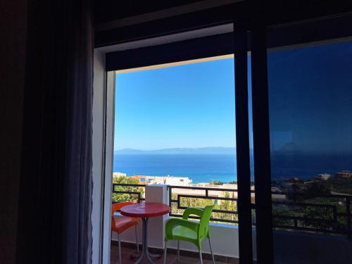 a balcony with a table and chairs and a view of the ocean at Blue Horizon-Ghougine in Tangier