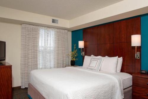 a bedroom with a large white bed and a window at Residence Inn Toledo Maumee in Maumee