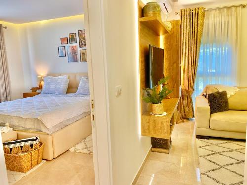 a bedroom with a bed and a tv and a couch at Beach Garden Paradise in Durrës