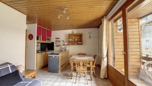 une cuisine avec une table et des chaises dans une pièce dans l'établissement Schuss 6 appartement 4 pax au pied des pistes, à Saint-Jean-dʼAulps